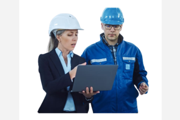 A man and woman in hard hats looking at something on a laptop.